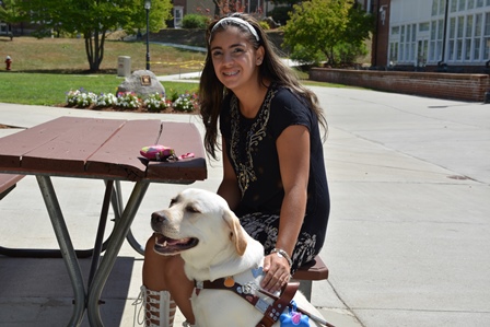 Student Stephanie V sitting outside with her service dog, Luna