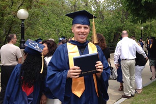 Former student Tyler L. holding diploma Commencement Day