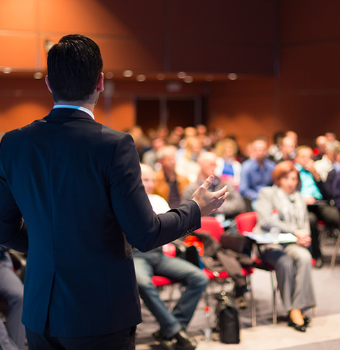 Image of a man speaking in front of an audience