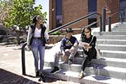 students sit outside brick building